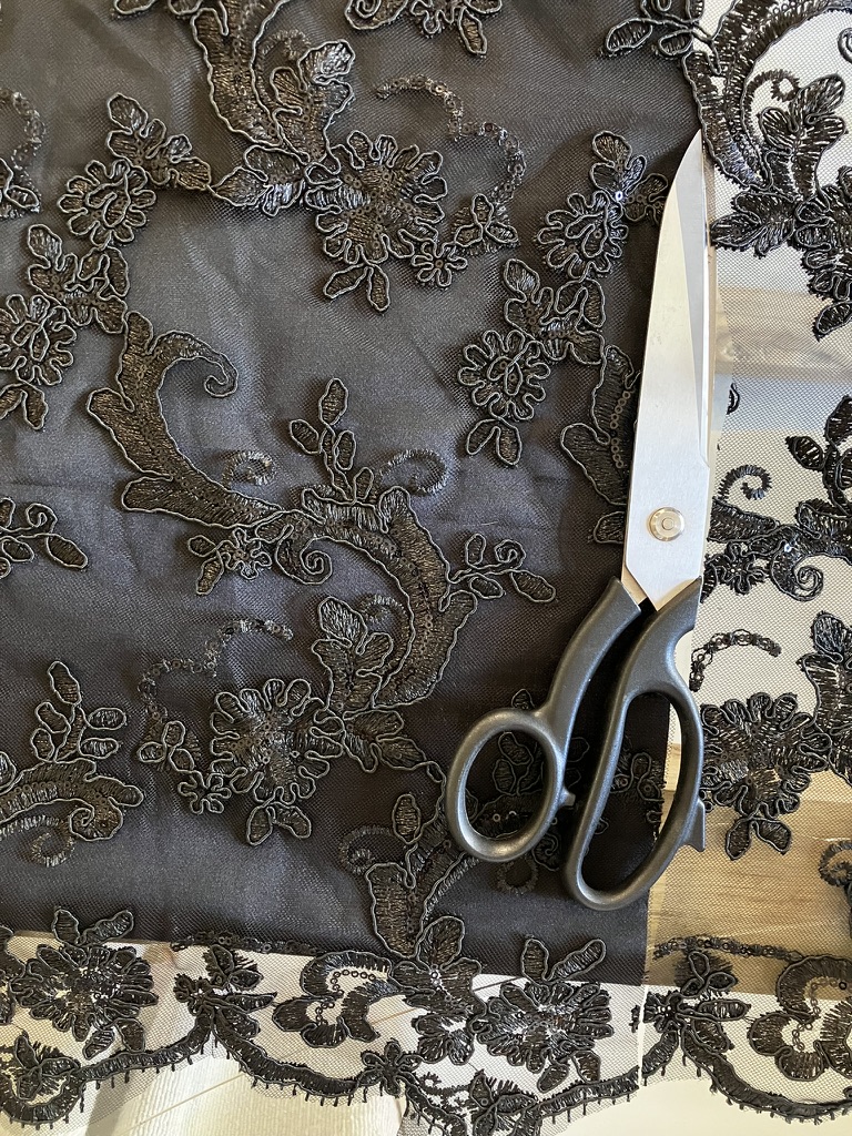 Scissors, tape measure and pins on a drafted pattern
