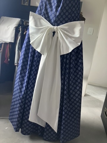 Ivory satin bow on a navy bridal-party dress