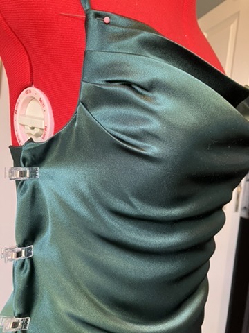 Emerald bias-cut dress on the stand