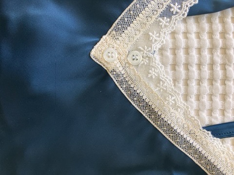Lace edging on navy satin, laid flat