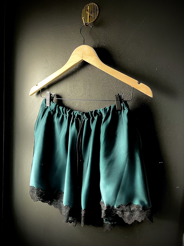 Teal satin shorts with black lace hem
